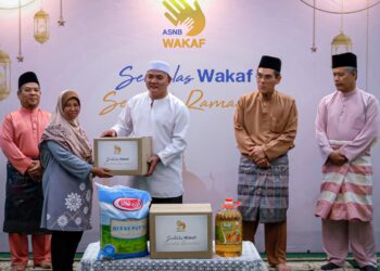 RAHMAD Mariman (tengah) menyampaikan Kit Syawal kepada penerima sambil disaksikan Ahmad Basri Ibrahim (dua dari kiri) pada Program Seikhlas Wakaf Seindah Ramadan di Masjid As-Salimin, Kampung Kandang, Melaka.