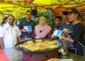 FUZIAH Salleh (tiga kiri) mengedarkan hebahan MySaveFood kepada para peniaga di Bazar Ramadan Jalan Raja Alang, Kuala Lumpur, baru-baru ini. - UTUSAN/FARIZ RUSADIO 