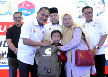 AZNAN Tamin menyampaikan bantuan persekolahan dalam Majlis Bantuan Kasih Murid di Pasir Gudang, Johor Bahru, hari ini. UTUSAN/RAJA JAAFAR ALI