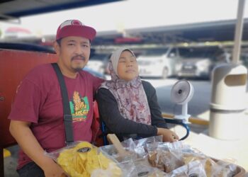 MOHAMAD Fackri Mohamad Diah bersama isterinya, Maizura gigih mencari rezeki menjual kerepek ketika ditemui di Nilai, baru-baru ini. - UTUSAN/NUR SHARIEZA ISMAIL