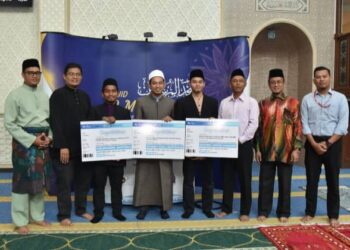 KETIGA-TIGA warga UPSI yang masing-masing bertugas di Universiti Oxford dan Australia (tengah, memegang replika cek) semasa majlis penyerahan replika tiket penerbangan di Masjid Al-Mursyidin, Pusat Islam UPSI, Tanjung Malim. - UTUSAN