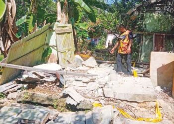 ROSTAM Azam menunjukkan dinding konkrit rumah jiran yang menghempap arwah adiknya, Allahyarham Mohd. Asri di Felda Kota Gelanggi Satu, Jerantut, kelmarin. – UTUSAN/HARIS FADILAH AHMAD