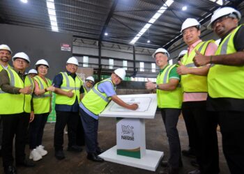 AMINUDDIN Harun (tengah) merasmikan Majlis Pelancaran Loji Janakuasa Biojisim Kilang Nestle Malaysia di Chembong, Rembau hari ini.-UTUSAN/MOHD. SHAHJEHAN MAAMIN