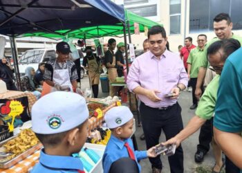 SHAHELMEY Yahya bersama rombongan mengagihkan buah kurma kepada pengunjung di Bazar Ramadan Putatan, di sini semalam