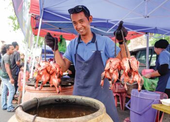 MUHAMMAD Shahrul Ramli menunjukkan ayam tempayan yang dijualnya di Bazar Ramadan Semabok Perdana, Melaka. – UTUSAN/SYAFEEQ AHMAD