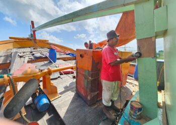 ABDDILAH Ghani melakukan kerja-kerja baik pulih bot nelayan di Pulau Duyung, Kuala Terengganu, semalam. – UTUSAN/ZAID MOHD. NOOR