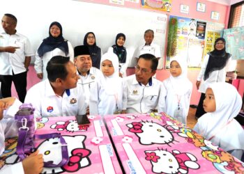 AZMAN Adnan (duduk, tiga dari kanan) beramah mesra dengan murid tahun satu Sekolah Kebangsaan (P) Sultan Ibrahim, Johor Bahru, semalam.