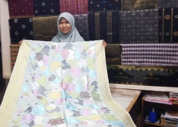 EMMA Surianti Che Mustaffa menunjukkan koleksi songket kain sampin yang dijual di Kuala Terengganu, semalam. - UTUSAN/KAMALIZA KAMARUDDIN