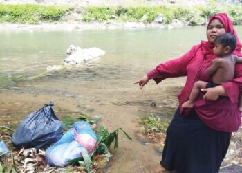 SITI Aishah Mohd. Sabri menunjukkan bungkusan sampah yang dijumpainya di tebing Sungai Ketil ketika berkelah di Kampung Lubuk Pedati, Baling, Kedah.