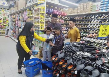 HAIM Hilman Abdullah (dua kanan) membantu seorang penerima mencuba songkok yang ingin dipakai ketika hari raya pada Majlis Iftar Ramadan Perdana dan Penyampaian sumbangan di Mydin Taman Batek, Sungai Petani.