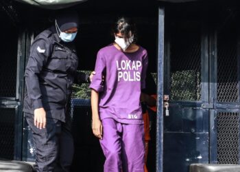 TAMILSELVI Anadan diiringi polis ketika dibawa ke Mahkamah Majistret Teluk Datok di Kuala Langat semalam. 
– UTUSAN/ AFIQ RAZALI