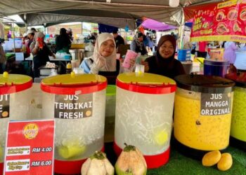 SHAHIDATUL Azirah Johan (kiri) bersama ibunya menunjukkan air balang yang dijual di Bazar Ramadan Papar.