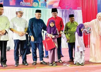 BUNG Moktar Radin (tiga kiri) menyampaikan bantuan kepada salah seorang asnaf pada Majlis Berbuka Puasa di Papar semalam.
