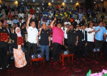 KETUA Menteri Melaka, Datuk Seri Ab. Rauf Yusoh mengangkat tangan mengetuai bapa angkat, jabatan angkat dan anak angkat untuk Sukma Ke-21 di Sarawak di Seri Negeri, Ayer Keroh, Melaka. - UTUSAN/AMRAN MULUP