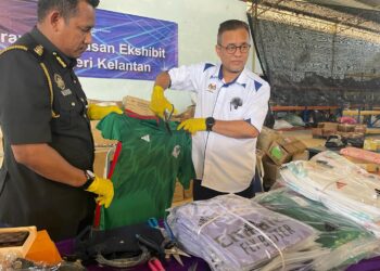 AZMAN Ismail (kanan) melupuskan barangan tiruan di Kandis, Bachok, Kelantan hari ini. UTUSAN/TOREK SULONG.