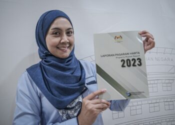 KAKITANGAN Jabatan Penilaian dan Perkhidmatan Harta, Suhaidahani Zainon menunjukkan buku Laporan Pasaran Harta 2023 yang dilancarkan Menteri Kewangan II Datuk Seri Amir Hamzah Azizan di Institut Penilaian Negara (INSPEN) di sini, hari ini.