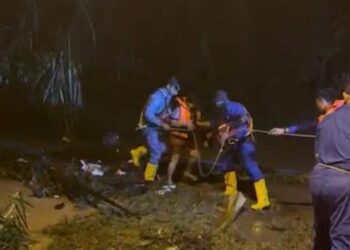 PASUKAN APM menyelamatkan seorang wanita warga emas terperangkap dalam kejadian banjir kilat di kebunnya di Kampung Tanah Merah Site A, di Chuah, Port Dickson malam semalam.