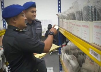 DUA anggota penguat kuasa KDPN Kelantan memeriksa barangan rampasan berupa aksesori alat ganti telefon tiruan dalam serbuan di Kota Bharu, Kelantan semalam-IHSAN KPDN KELANTAN.