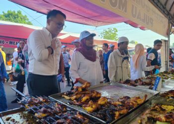DANIEL Gooi (kiri) ketika meninjau suasana bazar Ramadan di Bayan Baru, Pulau Pinang.-UTUSAN/IQBAL HAMDAN