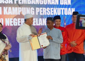 AHMAD Zahid Hamidi (dua kiri) menyerahkan watikah perlantikan Jawatankuasa Pembangunan dan Keselamatan Kampung (JPKK) Kelantan di Tanah Merah, Kelantan hari ini-UTUSAN/ROSMIZAN RESDI.