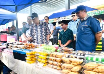 HAJIJI Noor (kiri) semasa melawat bazar Ramadan di Tuaran, Sabah, semalam.