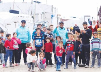 KANAK-kanak pelarian Syria bergambar bersama sukarelawan Al-Khair semasa lawatan di salah sebuah kem baru-baru ini.