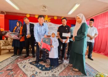 SAID Sidup (kiri) menyampaikan sumbangan kepada salah seorang penerima pada Majlis Penyerahan Bantuan Pasca Banjir Sempena Program Kembali Ke Sekolah 2024 dengan kerjasama Yayasan Sime Darby di Sekolah Kebangsaan (SK) Rahmat, Rantau Panjang, Kelantan hari ini-UTUSAN/YATIMIN ABDULLAH.