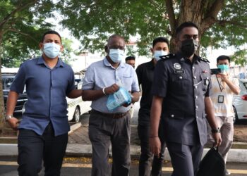 G. CHANDRASEGARAN (dua dari kiri) ketika dihadapkan ke Mahkamah Sesyen dan Majistret di Butterworth, Pulau Pinang.-UTUSAN/IQBAL HAMDAN