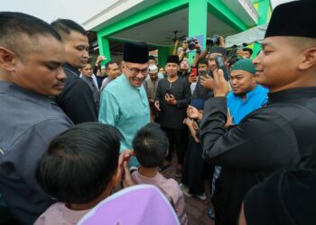 ANWAR Ibrahim (tengah) beramah mesra bersama orang ramai ketika hadir dalam majlis berbuka puasa bersama Perdana Menteri di Masjid Ashabus Solihin, Taman Rakan, Kajang, malam tadi.