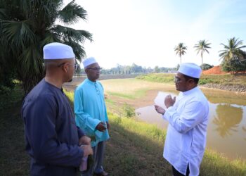 MUHAMMAD Husin (tengah) melihat paras air di Rumah Pam Kemubu selepas selesai menunaikan solat sunat istisqa' di Kemubu, Kelantan hari ini-UTUSAN/KAMARUL BISMI KAMARUZAMAN.