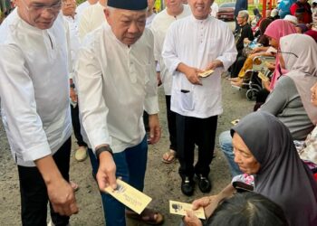 BUNG Moktar Radin (dua kiri) bersama Ketua Penerangan UMNO Sabah, Datuk Suhaimi Nasir (kiri) menyampaikan sumbangan kepada salah seorang penerima semasa majlis berbuka puasa di Sandakan semalam.