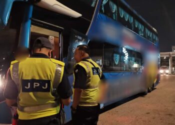 DUA anggota JPJ memeriksa sebuah bas dalam operasi bas ekspres di Pulau Pinang.