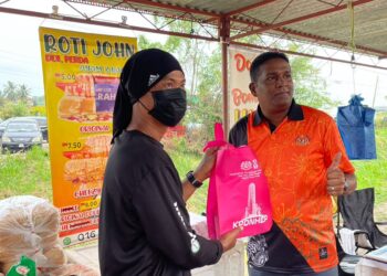 JEGAN (kanan) menyampaikan cenderamata kepada seorang peniaga ketika mengadakan 'walkabout' bersempena program Inisiatif ReDI di Kubang Semang, Bukit Mertajam, Pulau Pinang