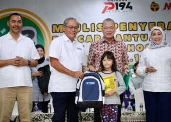 FADILAH Yusof (dua dari kanan) menyaksikan Philip Benedict Lasimbang menyampaikan bantuan persekolahan kepada murid daripada keluarga B40 pada Majlis Penyampaian Bantuan Persekolahan Yayasan Bank Rakyat di Kuching, hari ini.