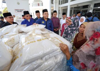 AZUAN Effendy Zairakithnaini (empat kiri) beramah mesra bersama asnaf yang menerima bantuan beras pada Majlis Penyerahan 25,000 Kampit Beras Kurniaan Yang di-Pertuan Agong di Masjid Saidina Hamzah, Kampung Batu Muda di Kuala Lumpur, semalam. - UTUSAN/FARIZ RUSADIO