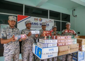 ROMLI Mustafa (tengah) menunjukkan sebahagian rokok seludup yang dilupuskan di Loji Rawatan Termal (insinerator) KampunG Belanga Pechah, Langkawi. - UTUSAN/SHAHIR NOORDIN