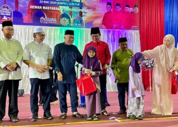 BUNG Moktar Radin (tiga kiri) menyampaikan bantuan kepada salah seorang asnaf pada majlis berbuka puasa di Papar semalam