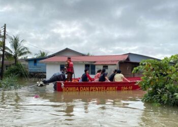 PASUKAN bomba dan penyelamat membantu memindahkan mangsa banjir di Sarawak.