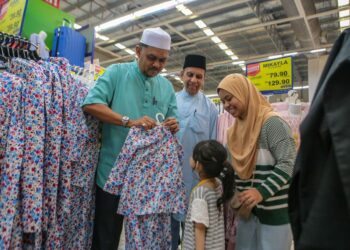 MUHAMMAD Radhi Mat Din (kiri) bersama Pengarah Eksekutif Mydin Wilayah Utara, Datuk Saduruddin Gulam Hussein membantu seorang kanak-kanak memilih baju raya pada Majlis Iftar Ramadan di Mydin Taman Saga, Alor Setar. -UTUSAN/ SHAHIR NOORDIN