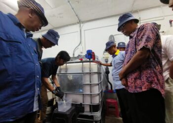 ISMAIL Salleh (kanan) melihat proses pembuatan cecair dolomite di sebuah kilang di Bukit Keteri di Padang Besar, Perlis, semalam. - UTUSAN/SYED AZLAN SAYID HIZAR