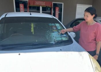 GAN Ay Ling menunjukkan keadaan cermin hadapan kenderaan yang pecah akibat dibaling bata dalam kejadian di kediamannya di Kangar, Perlis hari ini. - UTUSAN/ASYRAF MUHAMMAD