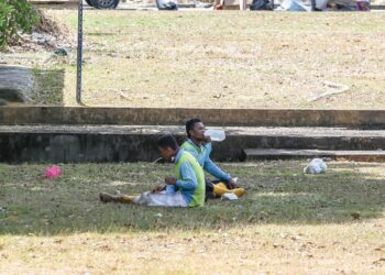 PEKERJA pembersihan meneguk minuman ketika berehat selepas membersihkan daun-daun kering yang banyak gugur akibat cuaca panas di Kedah. - UTUSAN/ SHAHIR NOORDIN