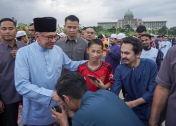 ANWAR Ibrahim beramah mesra denga orang ramai ketika hadir pada Program Majlis Iftar Madani (MIM) di Dataran Putra, Putrajaya. - UTUSAN/FAISOL MUSTAFA