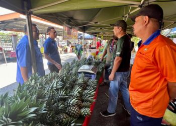 MOHD Anzara Azizan (dua dari kiri) melawat salah sebuah gerai yang beroperasi sewaktu Jualan Agro Madani Edisi Pra Ramadan di Pejabat FAMA Perlis. -UTUSAN/ASYRAF MUHAMMAD