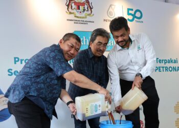 JOHARIAbdul Ghani (tengah) diiringi oleh Timbalan Ketua Setiausaha (Komoditi), Datuk Razali Mohamad (kiri) dan Pengarah Urusan Petronas Dagangan Berhad, Azrul Osman Rani (kanan) melakukan gimik meletakkan minyak masak terpakai ke dalam tong kutipan sebagai simbolik pelancaran Program Pengumpulan Minyak Masak Terpakai sempena Ikhlas Ramadan bersama Gas Petronas di Bazar Ramadan Desa Pandan di sini semalam.
