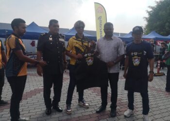 J. ARUL Kumar menerima cenderhati daripada wakil pihak penganjur pada Program MySaveFood di Bazar Ramadan Bandar Baru Nilai, Seremban, semalam.-UTUSAN/NUR SHARIEZA ISMAIL