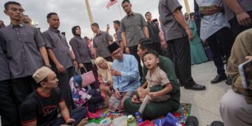 ANWAR Ibrahim beramah mesra denga orang ramai ketika hadir pada Program Majlis Iftar Madani (MIM) di Dataran Putra, Putrajaya. - UTUSAN/FAISOL MUSTAFA