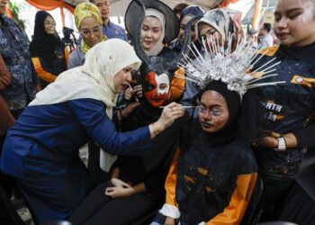 FADHLINA Sidek mencuba teknik solekan pada Majlis Perasmian Karnival Keusahawanan Permata Remaja di PPR Pantai Ria, Kuala Lumpur, hari ini. - UTUSAN/SHIDDIEQIIN ZON