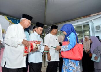 MOHD. Shafie Apdal (dua kiri) menyampaikan sumbangan kepada golongan asnaf semasa majlis berbuka puasa di Putatan semalam