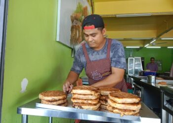 JASMIZAN Mohamad menyediakan martabak untuk pelanggan berbelanja juadah berbuka puasa di restoran Murtabak Ferry di Jerantut Feri, Jerantut, Pahang. -UTUSAN/HARIS FADILAH AHMAD